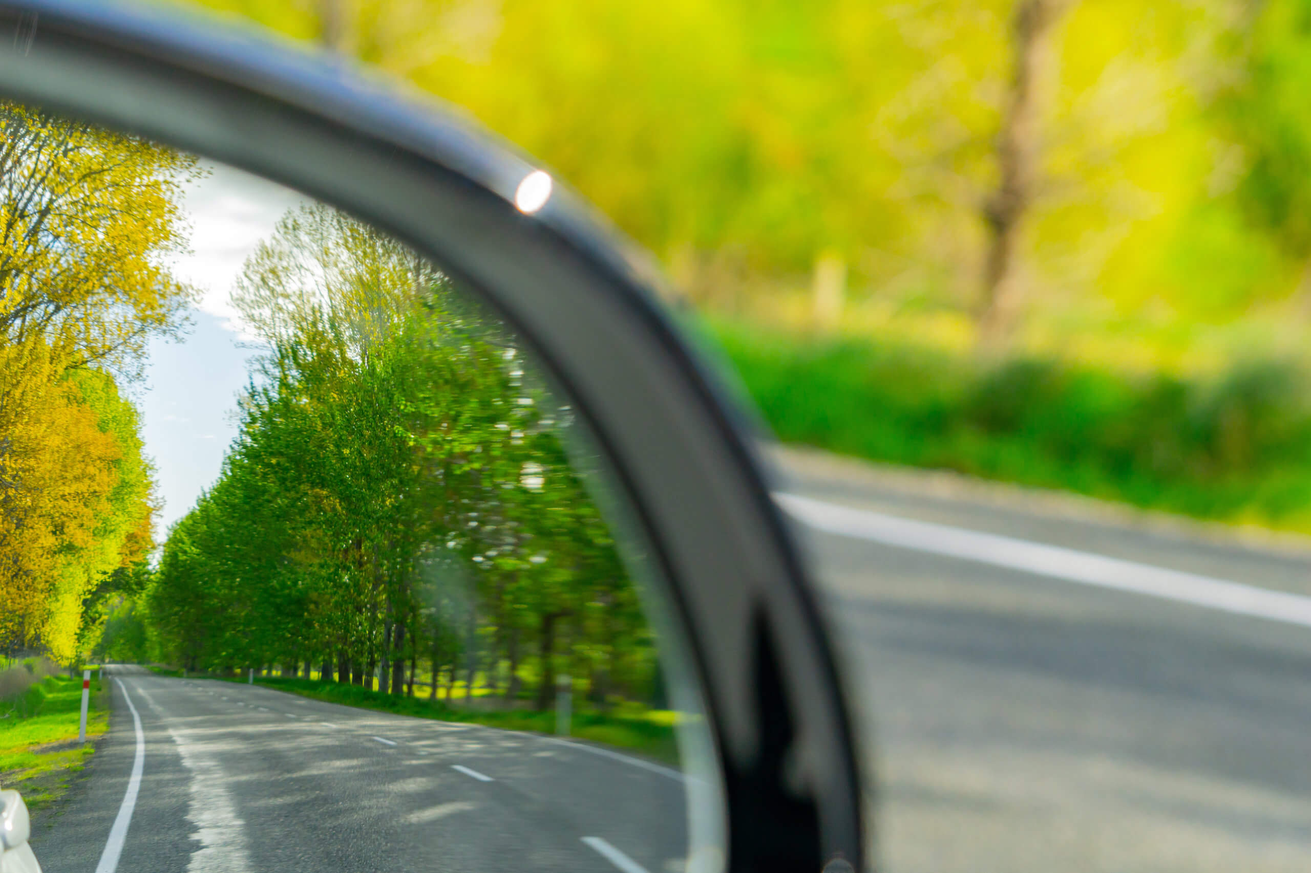 Safety road check in rear vision mirror while driving scenic South Island road